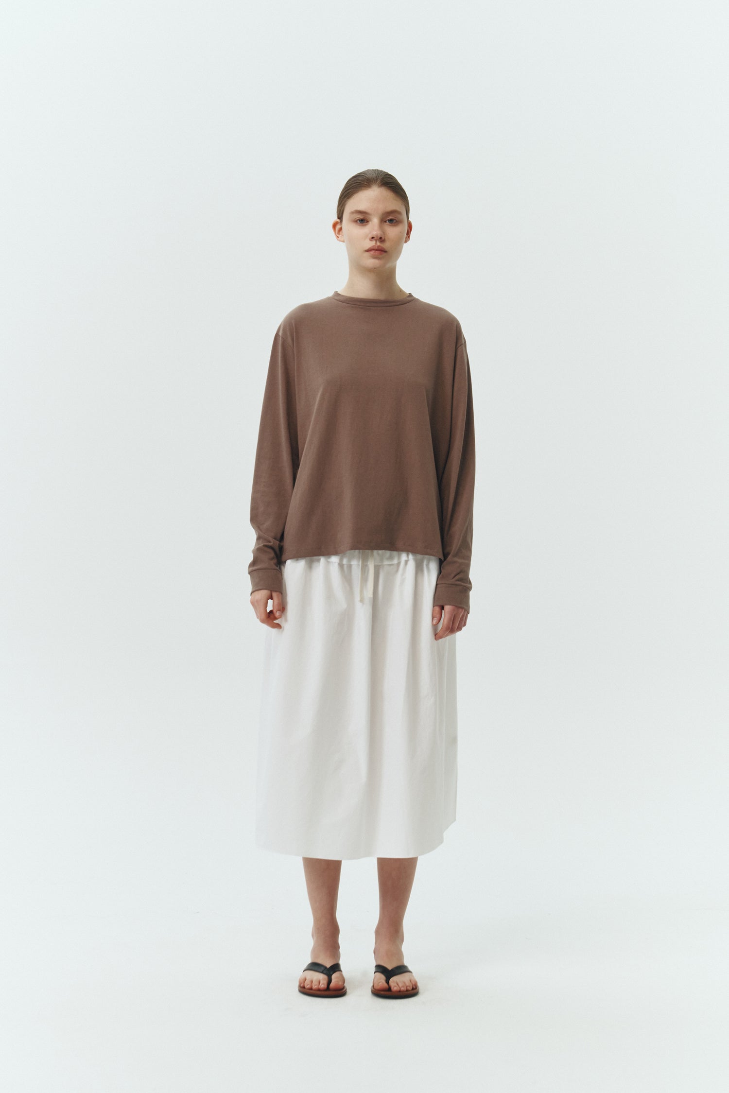 Lara Long-Sleeved T-Shirt in brown, a lightweight cotton crew-neck tee with long sleeves and relaxed fit, ideal for everyday wear and seasonal layering