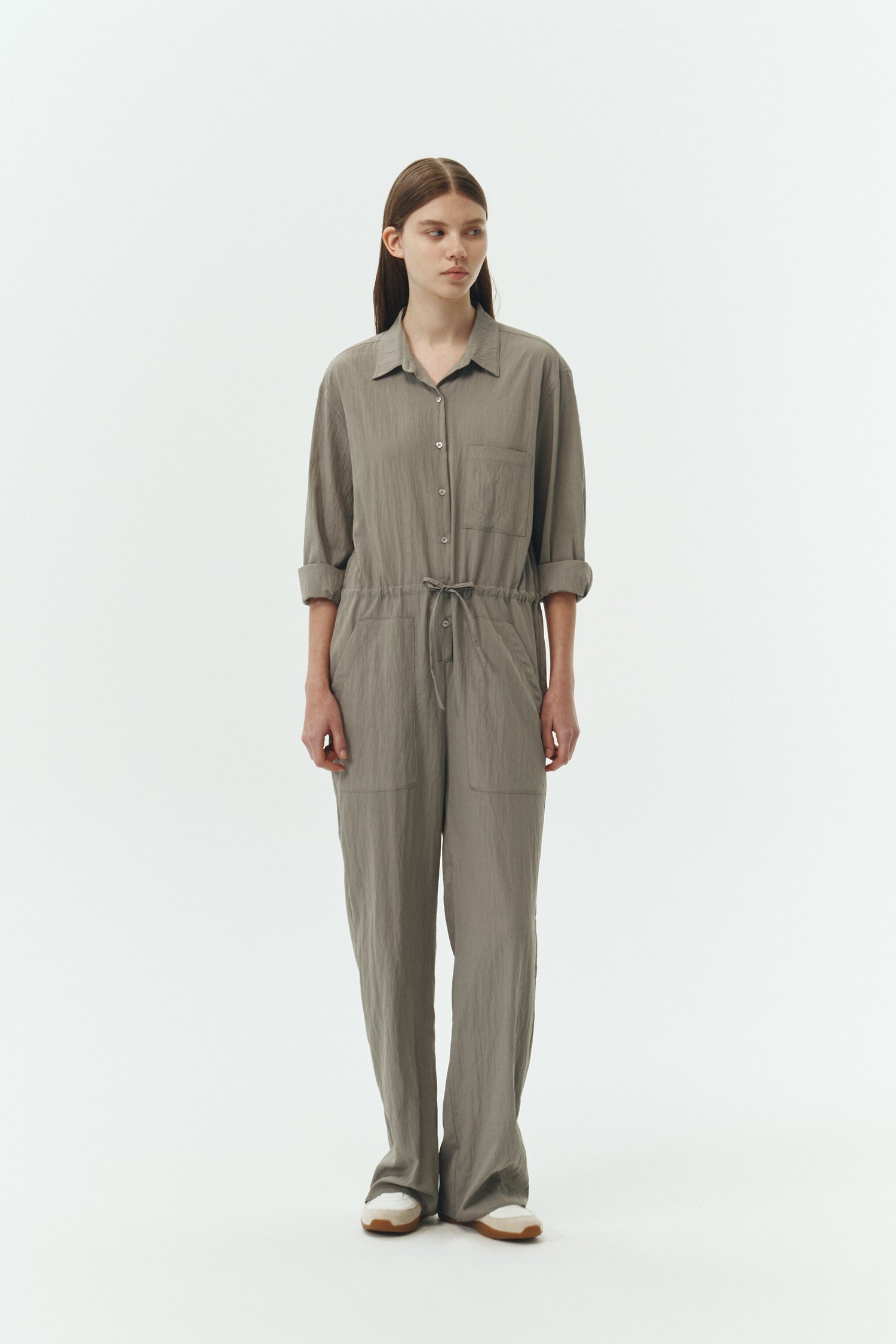 Saige Jumpsuit in khaki gray, long-sleeve rayon blend jumpsuit with point collar, front button closure, drawstring waist, and patch pockets.