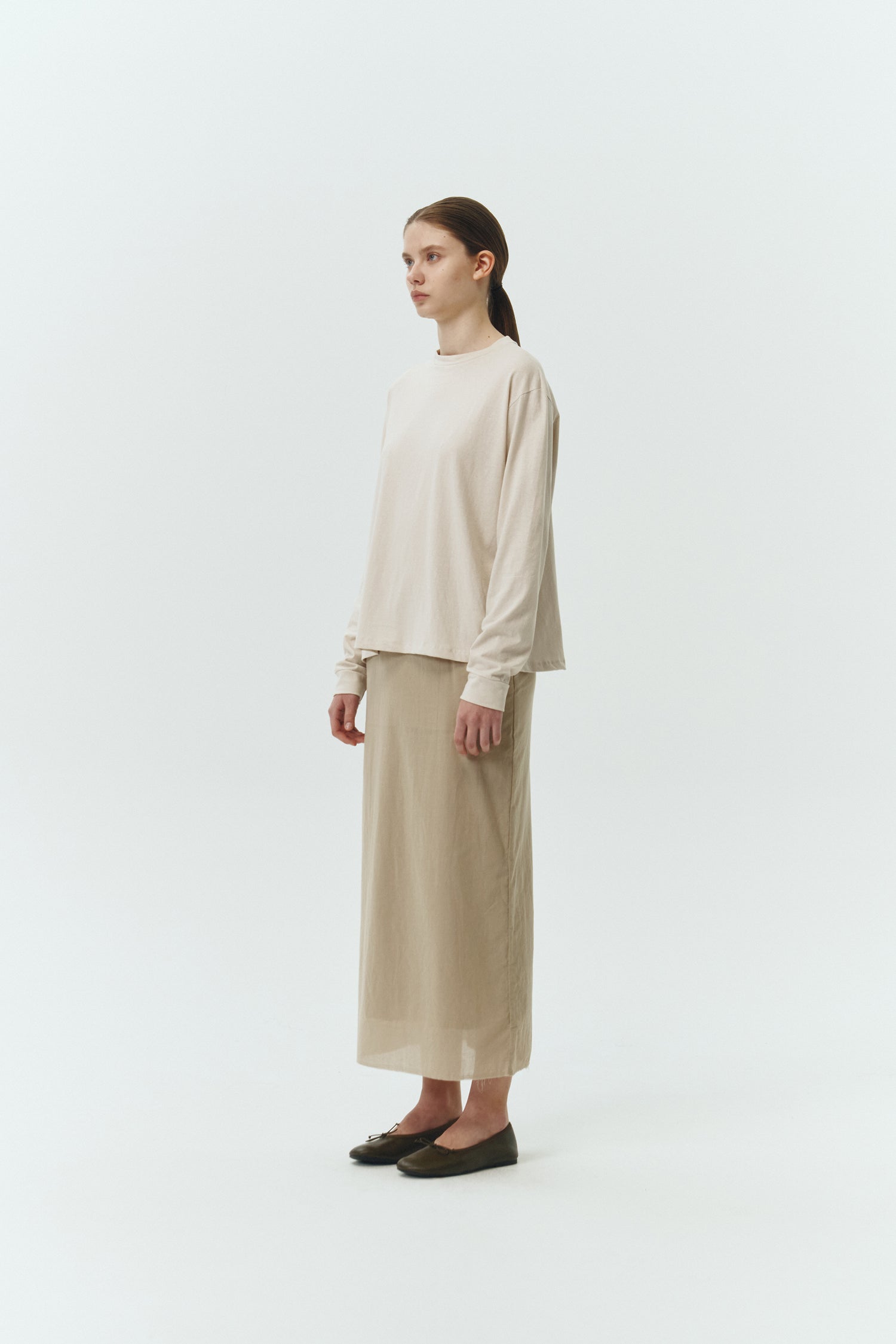 Amelia Skirt in sand, a lightweight cotton midi skirt with inner drawstring waist, hidden side pockets, lined layers, raw-edge hem, and a center back slit for ease and movement