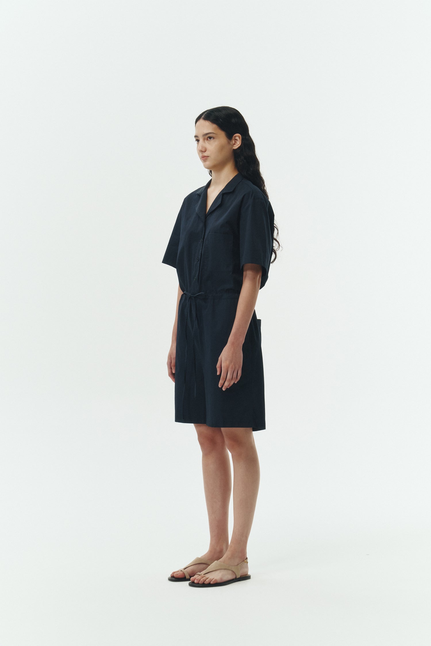 Emma Jumpsuit in navy, short-sleeve cotton jumpsuit with camp collar, front buttons, drawstring waist, and multiple pockets.