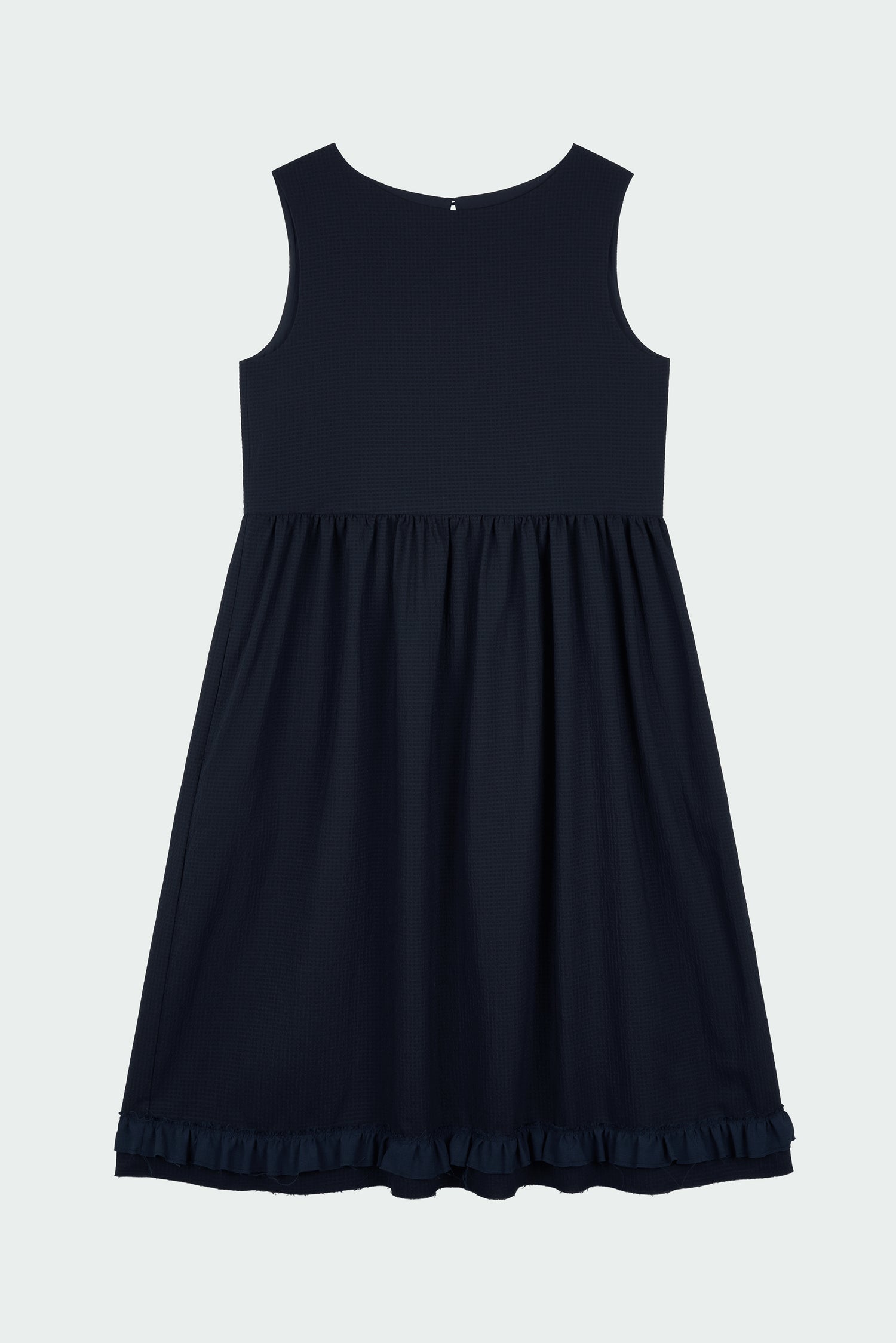 Pina Dress in navy, sleeveless cotton midi dress with shirring at waist and hem, hidden side pockets, and an open back with button closure.