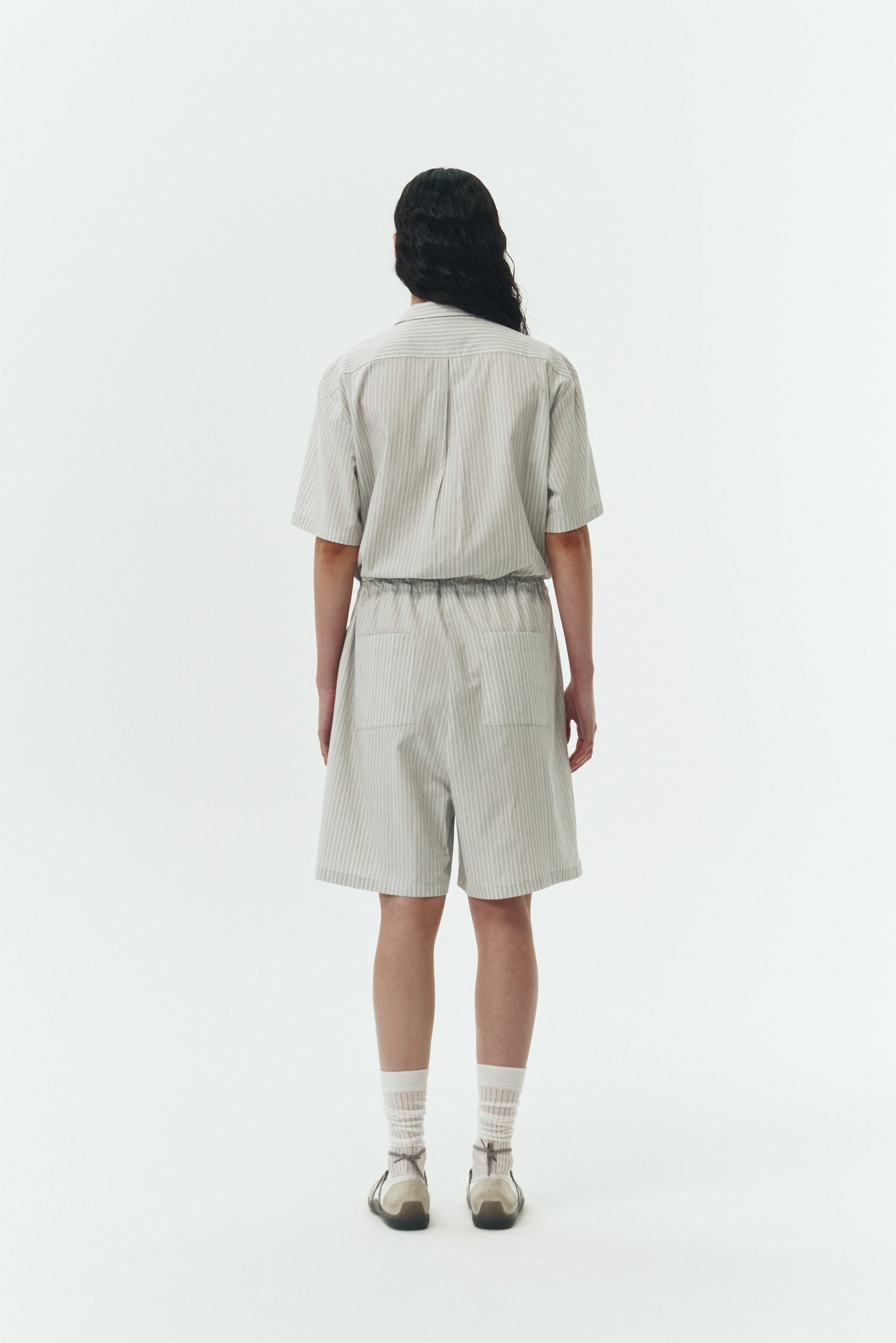 Emma Jumpsuit in stripe, short-sleeve cotton jumpsuit with camp collar, front buttons, drawstring waist, and multiple pockets.