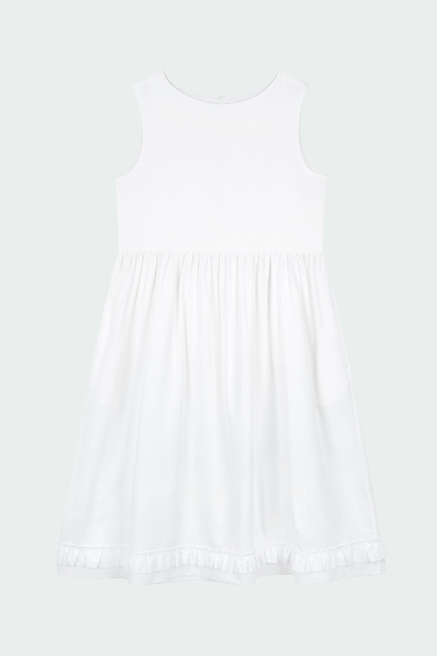 Pina Dress in white a sleeveless midi dress with an open back and button closure, featuring shirring details at the waist and hem, plus hidden side pockets for summer comfort