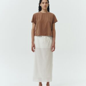 Amelia Skirt in white, a lightweight cotton midi skirt with inner drawstring waist, hidden side pockets, lined layers, raw-edge hem, and a center back slit for ease and movement