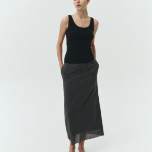 Amelia Skirt in charcoal, a lightweight cotton midi skirt with inner drawstring waist, hidden side pockets, lined layers, raw-edge hem, and a center back slit for ease and movement