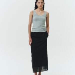 Amelia Skirt in black, a lightweight cotton midi skirt with inner drawstring waist, hidden side pockets, lined layers, raw-edge hem, and a center back slit for ease and movement