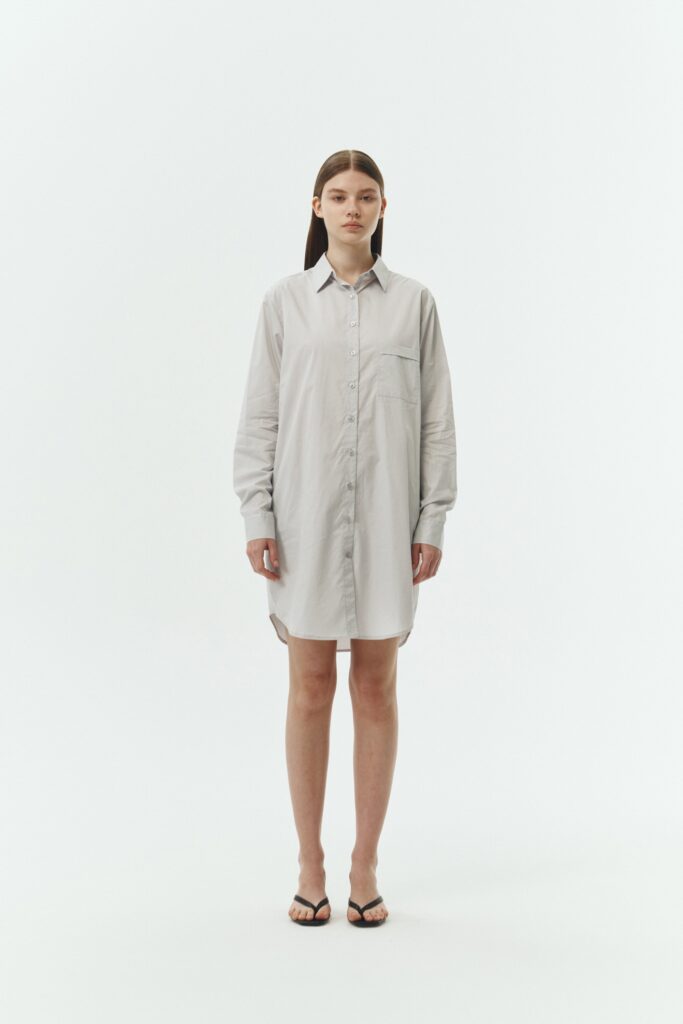 Cara Dress in cloud gray, long sleeve cotton shirt dress with front chest pocket, curved hem, hidden side pockets, and a relaxed silhouette.
