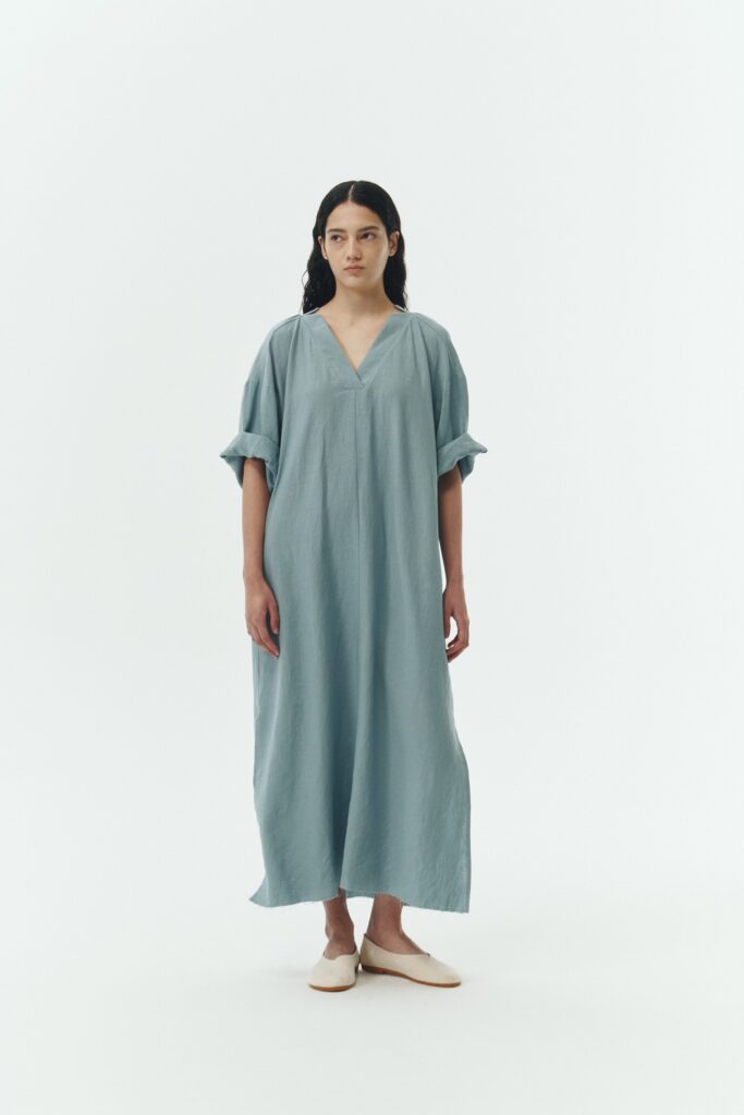 Charlotte Dress in light blue, V-neck summer maxi dress in a lightweight linen-rayon blend with drop shoulders, hidden side pockets, raw edge hem, and a relaxed fit.