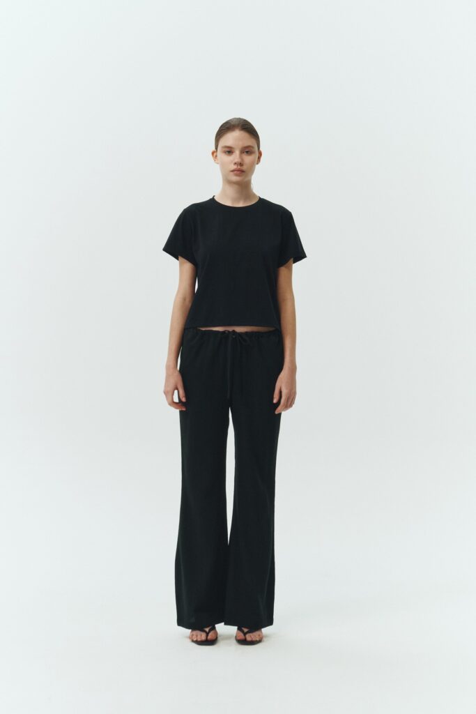 Chloe Pants in black, lightweight cotton pants with a drawstring waist, side pockets, and a flared bottom, relaxed fit for effortless everyday wear