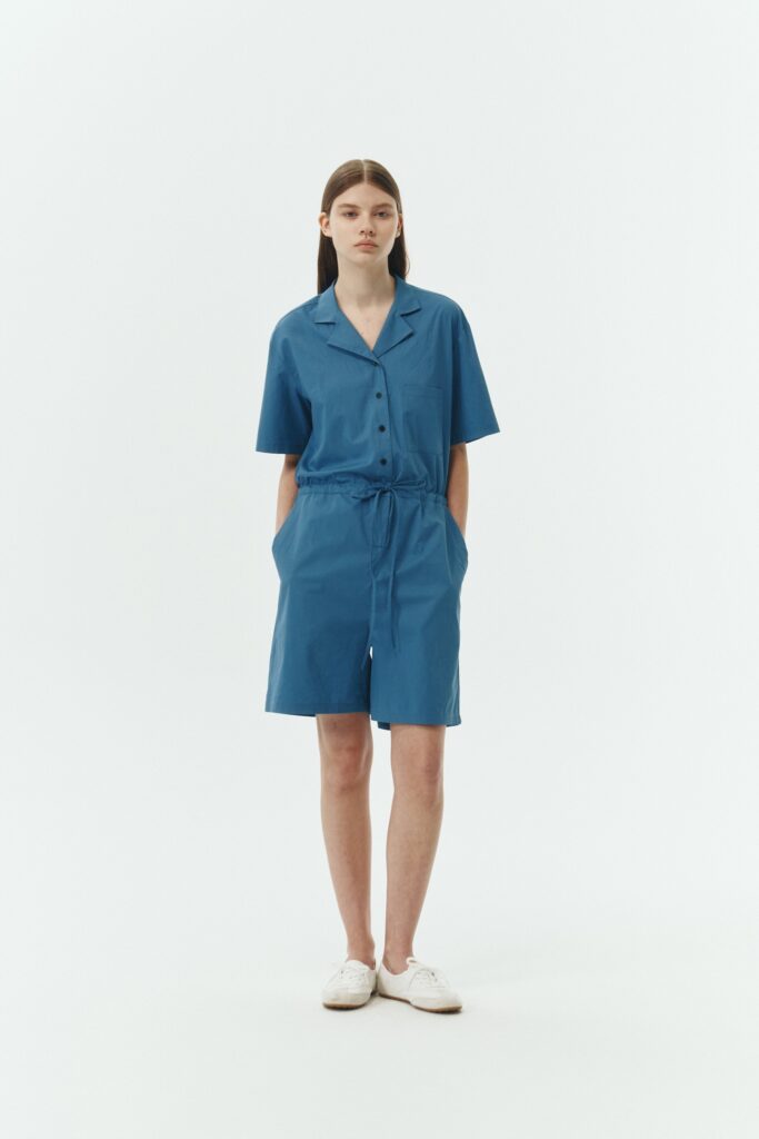 Emma Jumpsuit in blue green, short-sleeve cotton jumpsuit with camp collar, front buttons, drawstring waist, and multiple pockets.