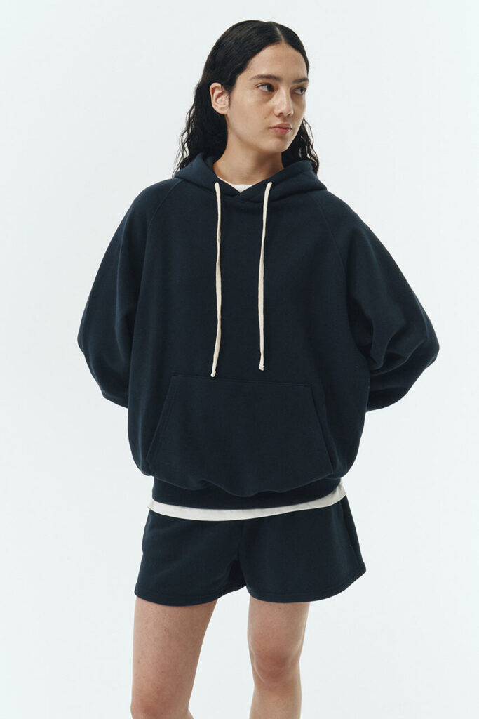 Kaia Hoodie in navy, oversized cotton French terry pullover with drawstring hood, raglan sleeves, kangaroo pocket, and ribbed trims.